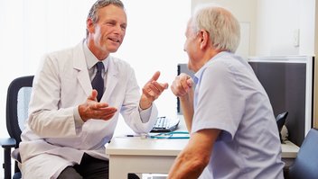 Arzt berät älteren Patienten über Therapiemöglichkeiten